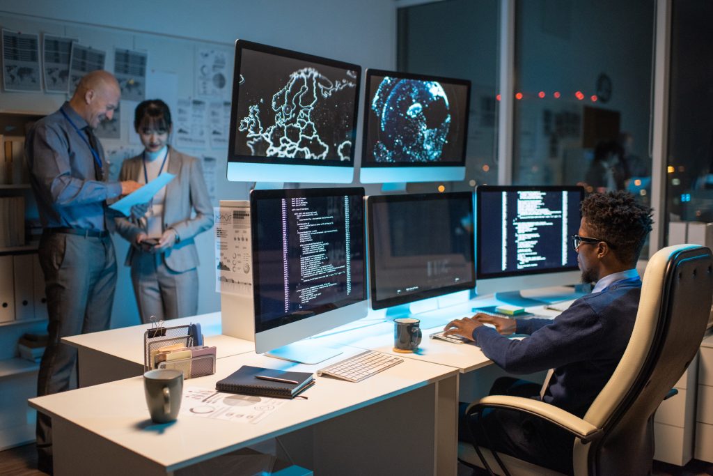 Young African businessman looking at data on computer screen