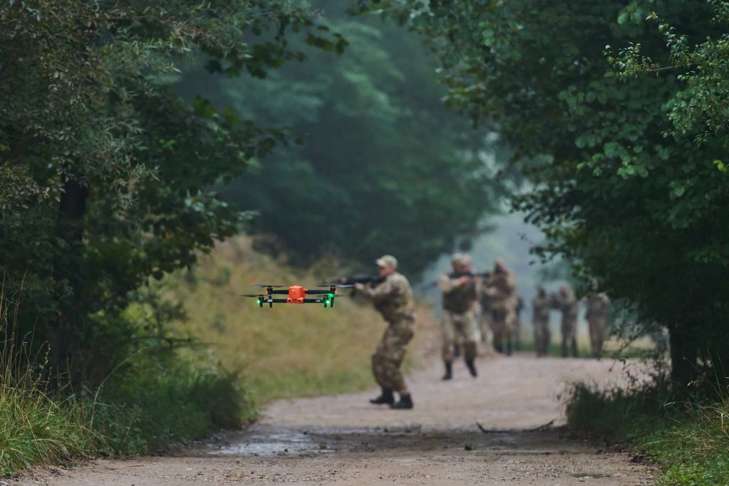 Elite military unit securing forest, using drone for terrain scan